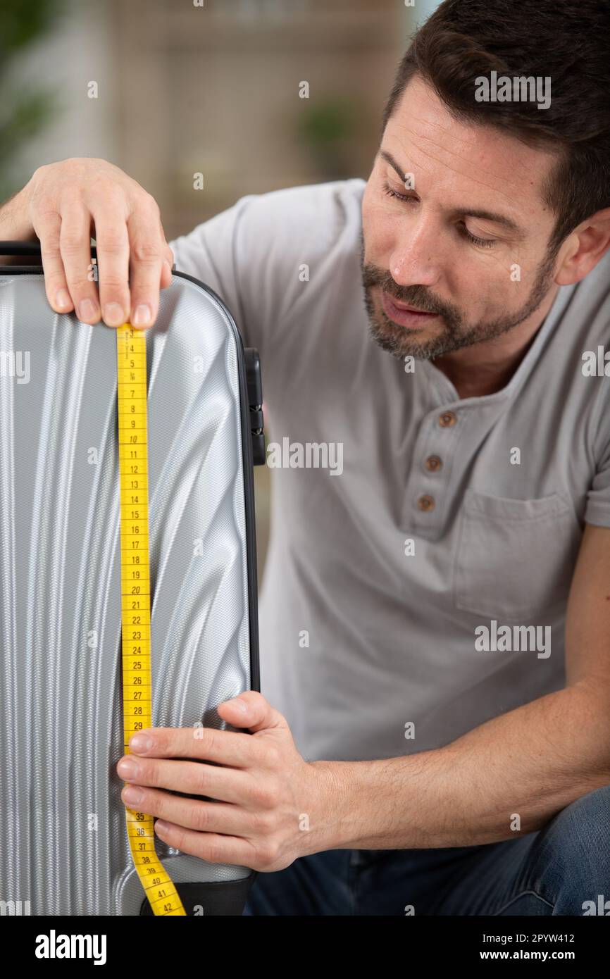 man checking her luggage measurments before vacation Stock Photo