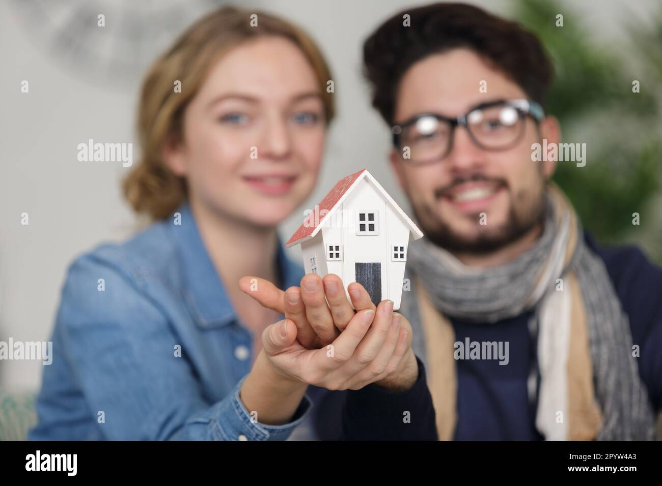 model house in the hands of a young couple Stock Photo - Alamy