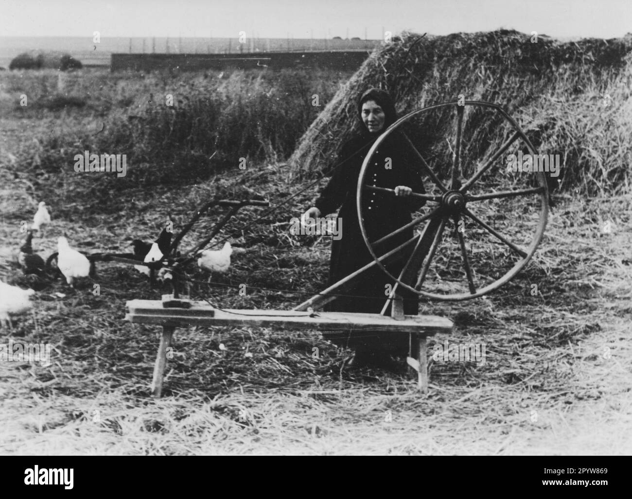 A woman with her spinning wheel in the German settlement Seraphimowka. According to the caption, the woman's name is Christine Mälzel. Photo: Rebhahn. [automated translation] Stock Photo