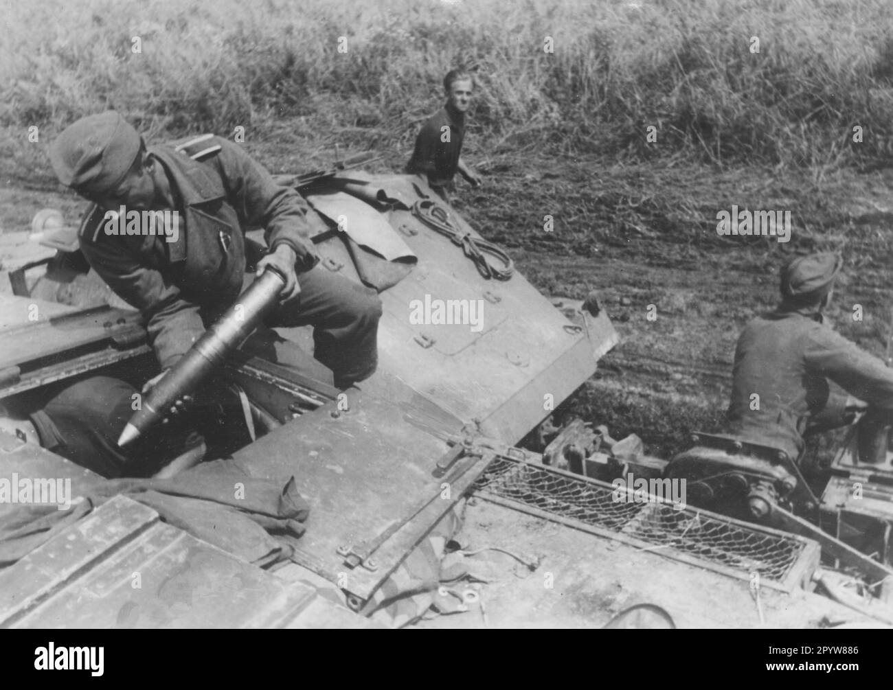An assault gun III is being ammunitioned. Behind the gun a Sdkfz. 252, an ammunition transporter based on a half-track vehicle. Photo: Knödler. [automated translation] Stock Photo