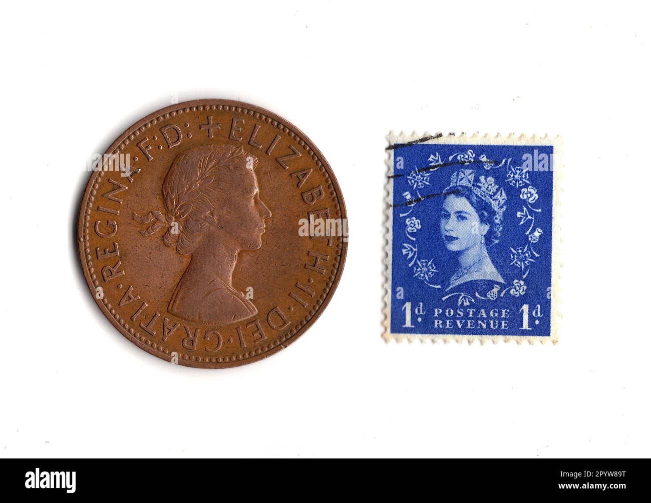 Penny coin and stamp from the reign of Queen Elizabeth II isolated on a white background. Stock Photo