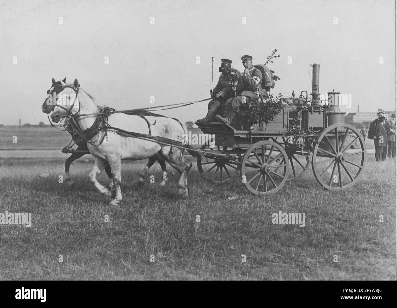 Horse-drawn wagon of a medical column with an apparatus for distilling water. The picture was probably taken at the outbreak of war and the march to the front, because the passenger has a bouquet of flowers in his rifle. [automated translation] Stock Photo