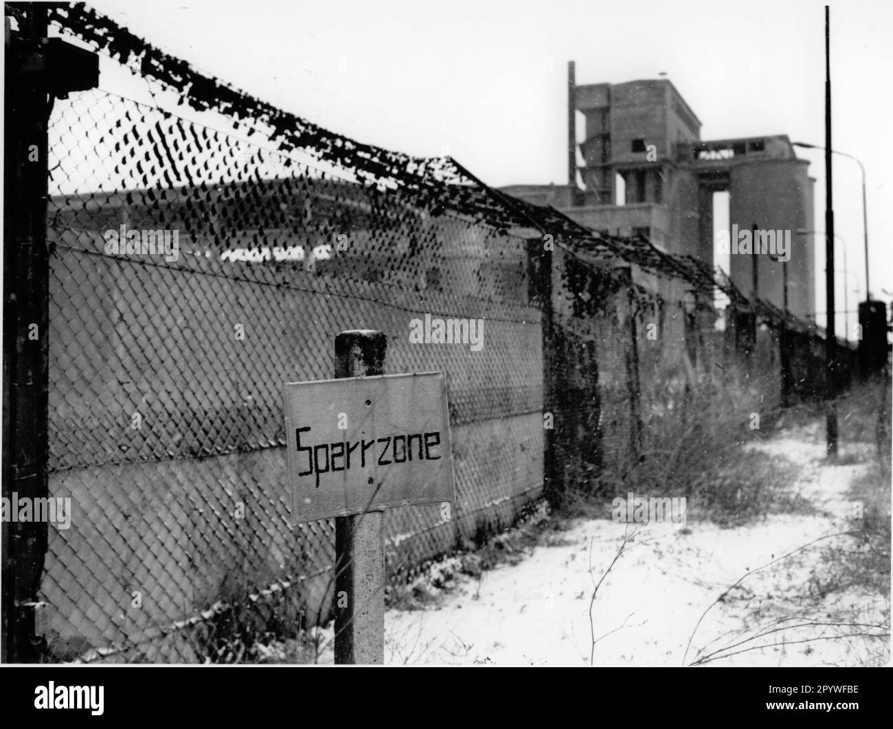 ' East Germany, Rüdersdorf. After the fall of the Wall: Decommissioned lime works near Köpenick. Sign ''exclusion zone'' in front of the fence. View, black and white. Photo, winter 1991.' Stock Photo