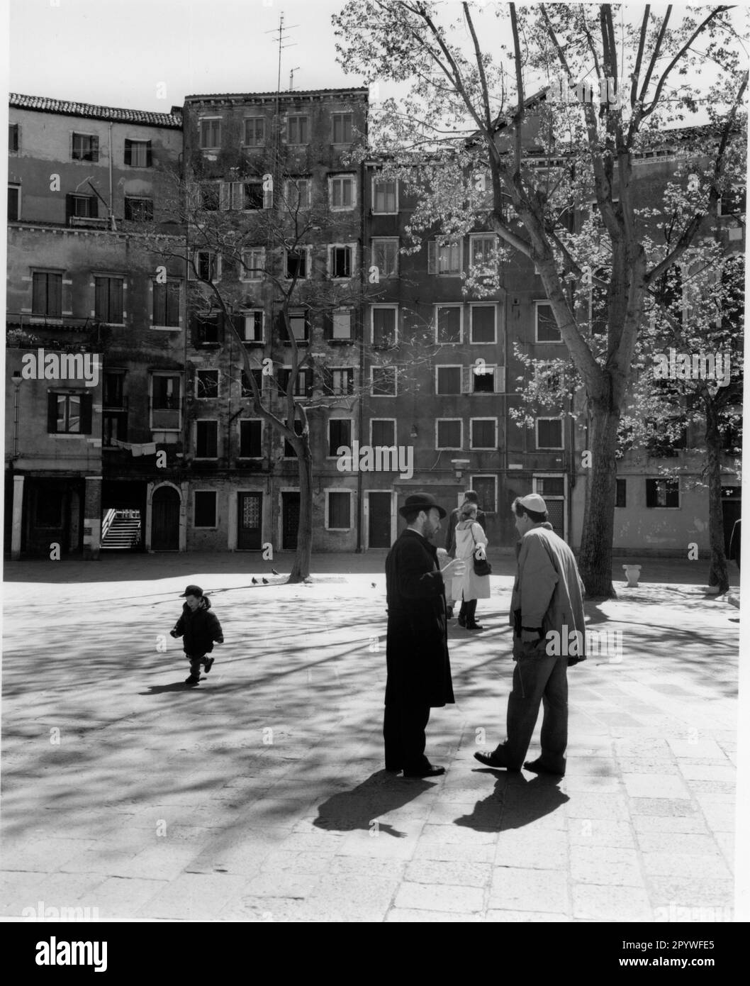 Venice, Venezia (Italy), Ghetto (established in 1516 by decision of the Venezuelan government, Jewish quarter): Campo del Ghetto Nuovo. View of the square with the eight-story residential buildings due to lack of space. Street scene, black and white. Photo, 1997. Stock Photo