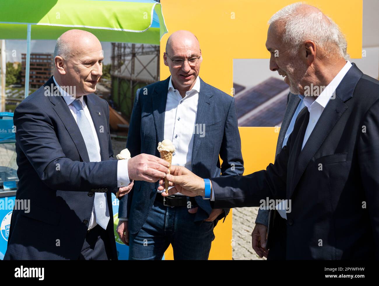 Berlin, Germany. 05th May, 2023. Kai Wegner (CDU, l), Governing Mayor of Berlin, hands an ice cream to Reinhard Müller (r), CEO EUREF AG. The EUREF Campus Berlin celebrates the topping-out ceremony in the Schöneberg gasometer on the occasion of its renovation in accordance with the preservation order. EUREF AG is a private-sector developer of energy- and environmentally optimized real estate. Credit: Hannes P. Albert/dpa/Alamy Live News Stock Photo
