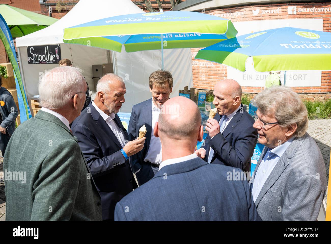 Berlin, Germany. 05th May, 2023. Reinhard Müller (l-r), CEO EUREF AG, Richard Lutz, CEO Deutsche Bahn AG, and Kai Wegner (CDU), governing mayor of Berlin, eat ice cream at the topping-out ceremony. The EUREF Campus Berlin celebrates its topping-out ceremony in the Schöneberg Gasometer on the occasion of its renovation in accordance with the preservation order. EUREF AG is a privately owned developer of energy and environmentally optimized real estate. Credit: Hannes P. Albert/dpa/Alamy Live News Stock Photo