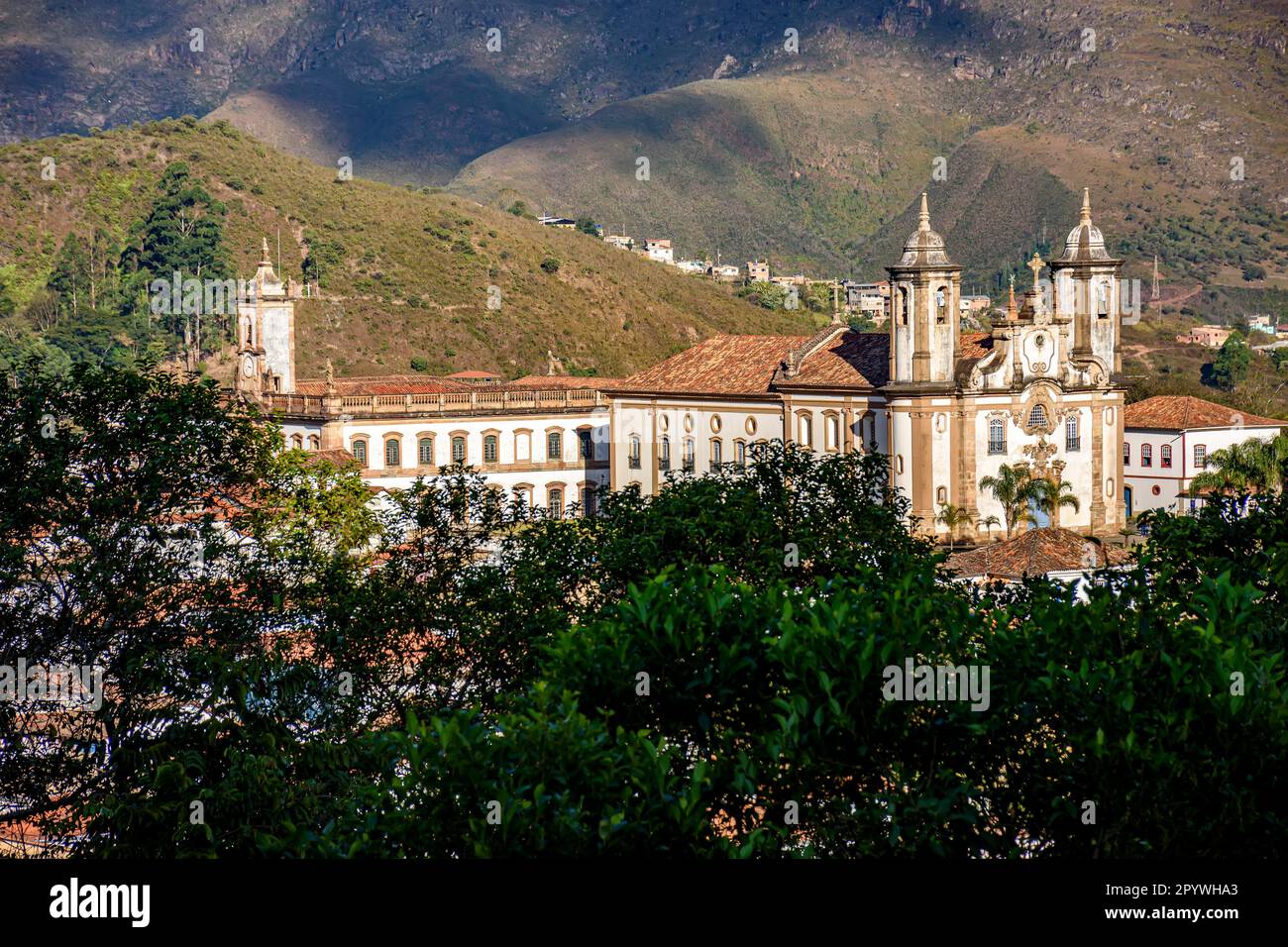 Baroque churches in Ouro Preto between the vegetation and mountains of the city, Brasil Stock Photo