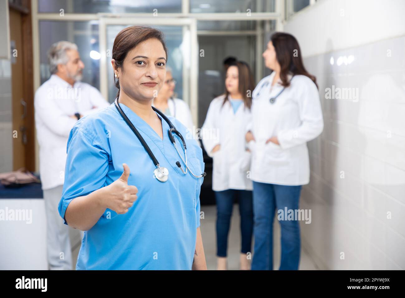 Indian female nurse and medical staff wearing stethoscope standing at hospital corridor, healthcare and medical concept. Stock Photo