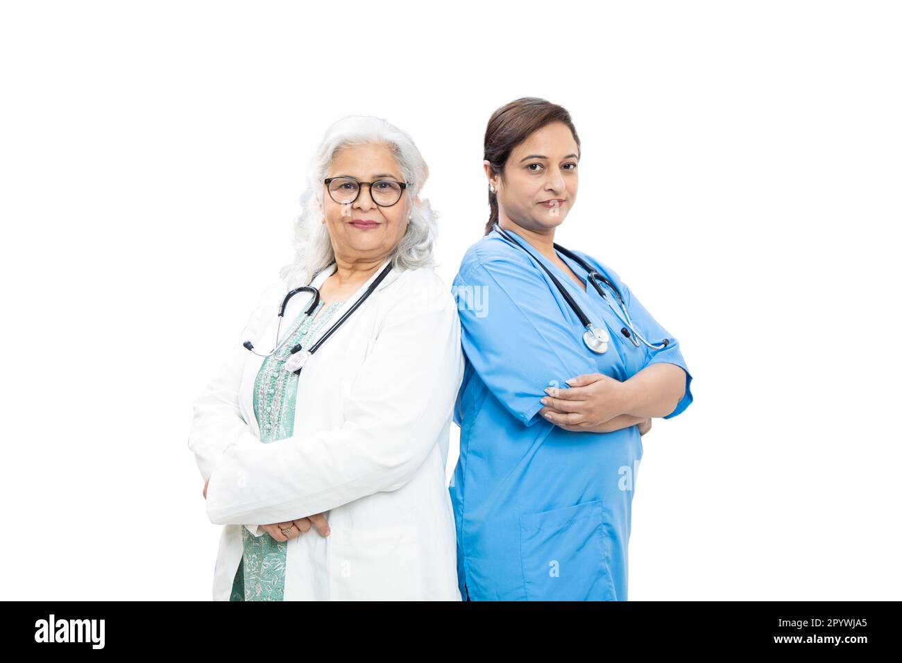 Portrait of senior indian female doctor and nurse with stethoscope standing isolated over white background, healthcare and medical concept. Stock Photo