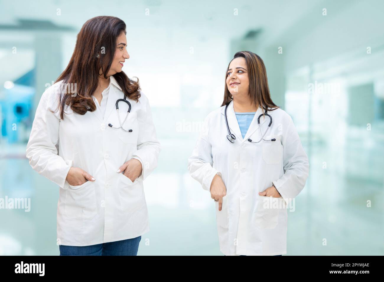 Two Indian female doctors and discussing while walking in hospital