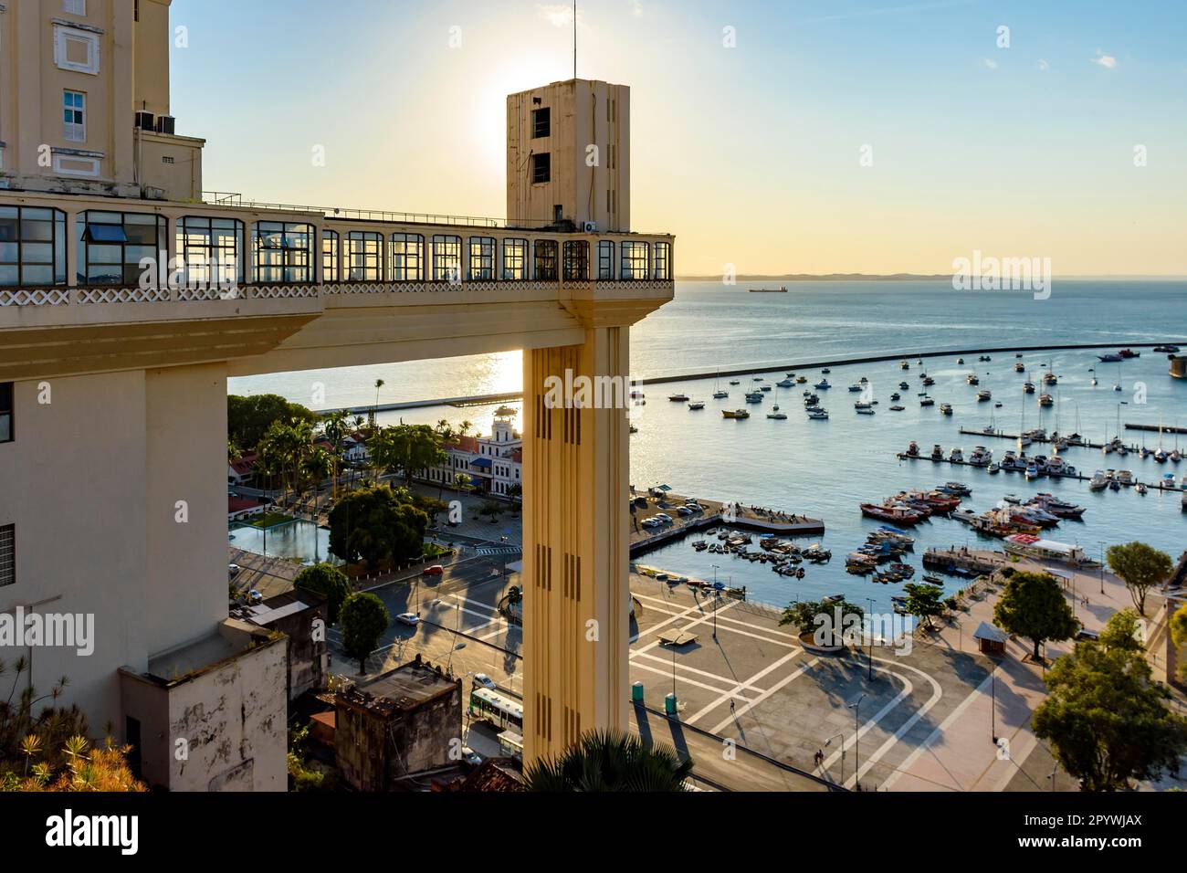 Sunset in the city of Salvador behind the Lacerda elevator with the Bay of All Saints and its boats in the background, Brasil Stock Photo
