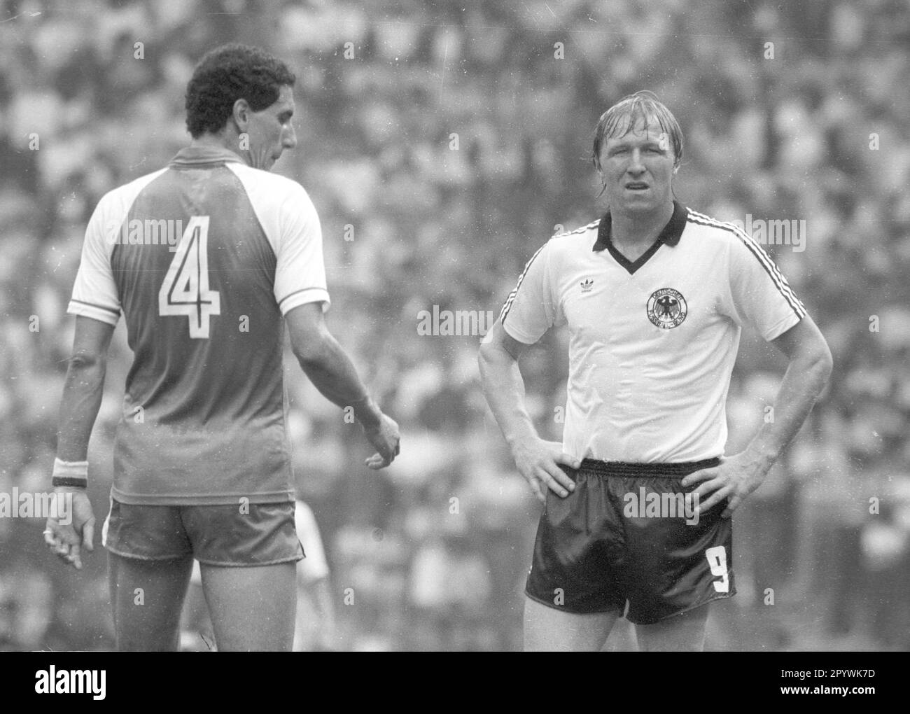 Football World Cup 1982 in Spain. Preliminary round: Algeria - Germany 2:1 / 16.06.1982 in Gijon. / Horst Hrubesch (FRG) at a loss. Left: Nourredine Kourichi (ALG/4). [automated translation] Stock Photo