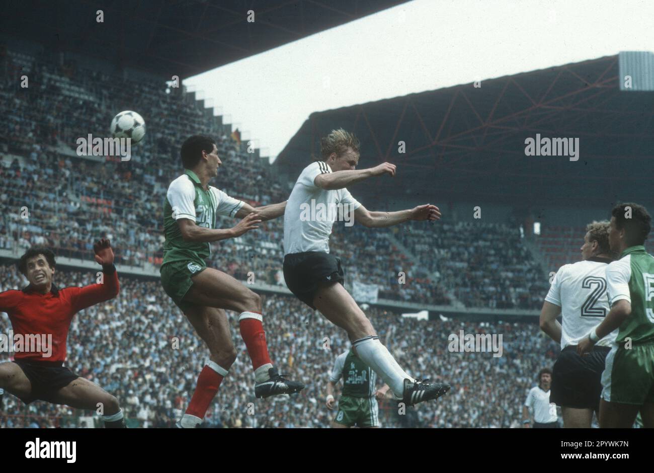 Football World Cup 1982 in Spain. Preliminary round: Algeria - Germany 2:1 / 16.06.1982 in Gijon. / Header scene in the Algerian penalty area. Center: Horst Hrubesch (FRG) against Nourredine Kourichi. Far left: Tw. Mehdi Cerbah (both ALG). Re.: Hans-Peter Briegel (FRG/2) and Chaabane Merzekane (5/ALG). [automated translation] Stock Photo