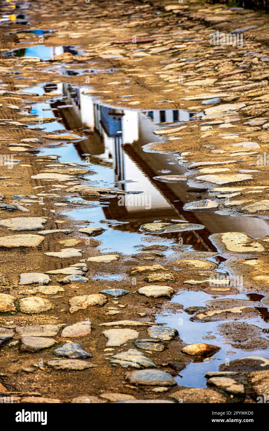 Reflections of an old colonial style house in a puddle in the ...