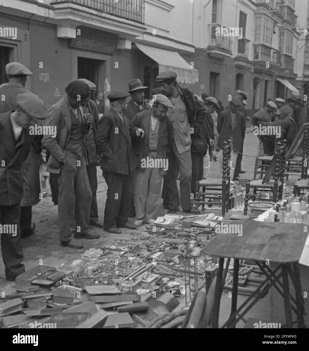 Men look at a stand with tool. On a market in Morocco goods are sold on