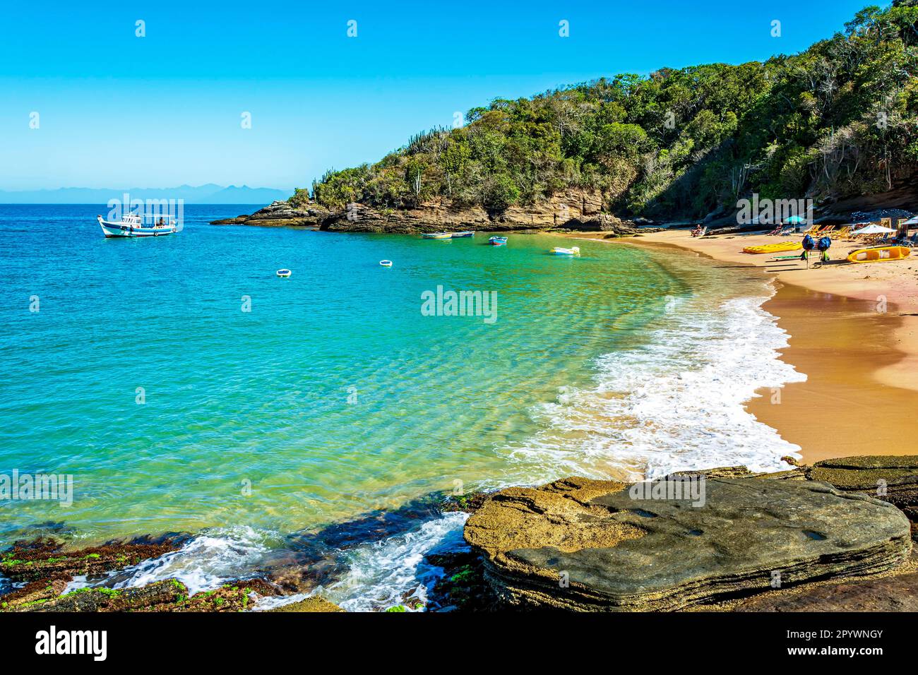 Paradise beach with colorful transparent waters surrounded by stones and vegetation in the city of Buzios, one of the main tourist destinations in Stock Photo