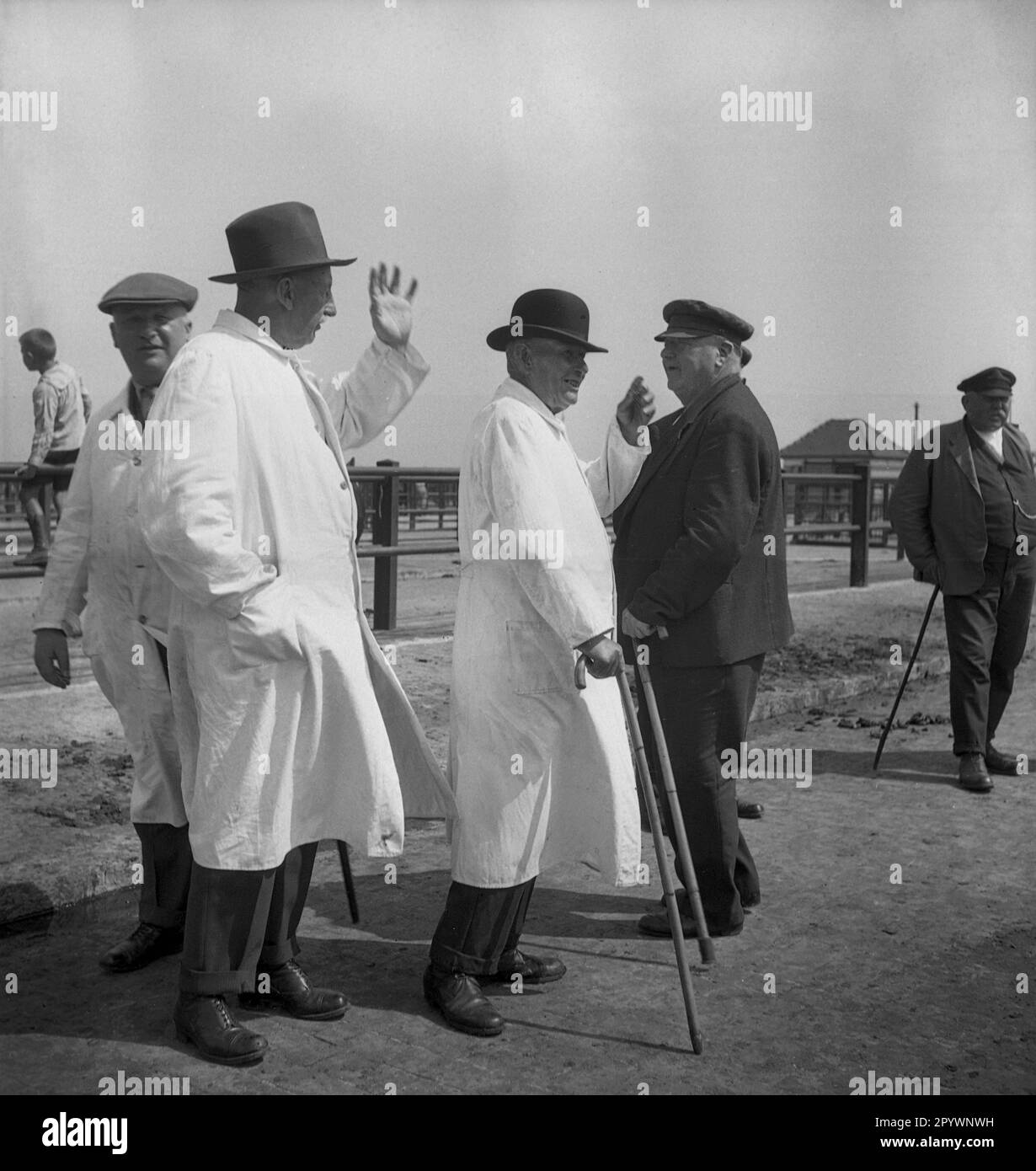 Undated photograph of a group of cattle dealers (some in white coats) greeting each other at the Magerviehmarkt (new cattle market) in Husum, North Friesland, Schleswig-Holstein. [automated translation] Stock Photo