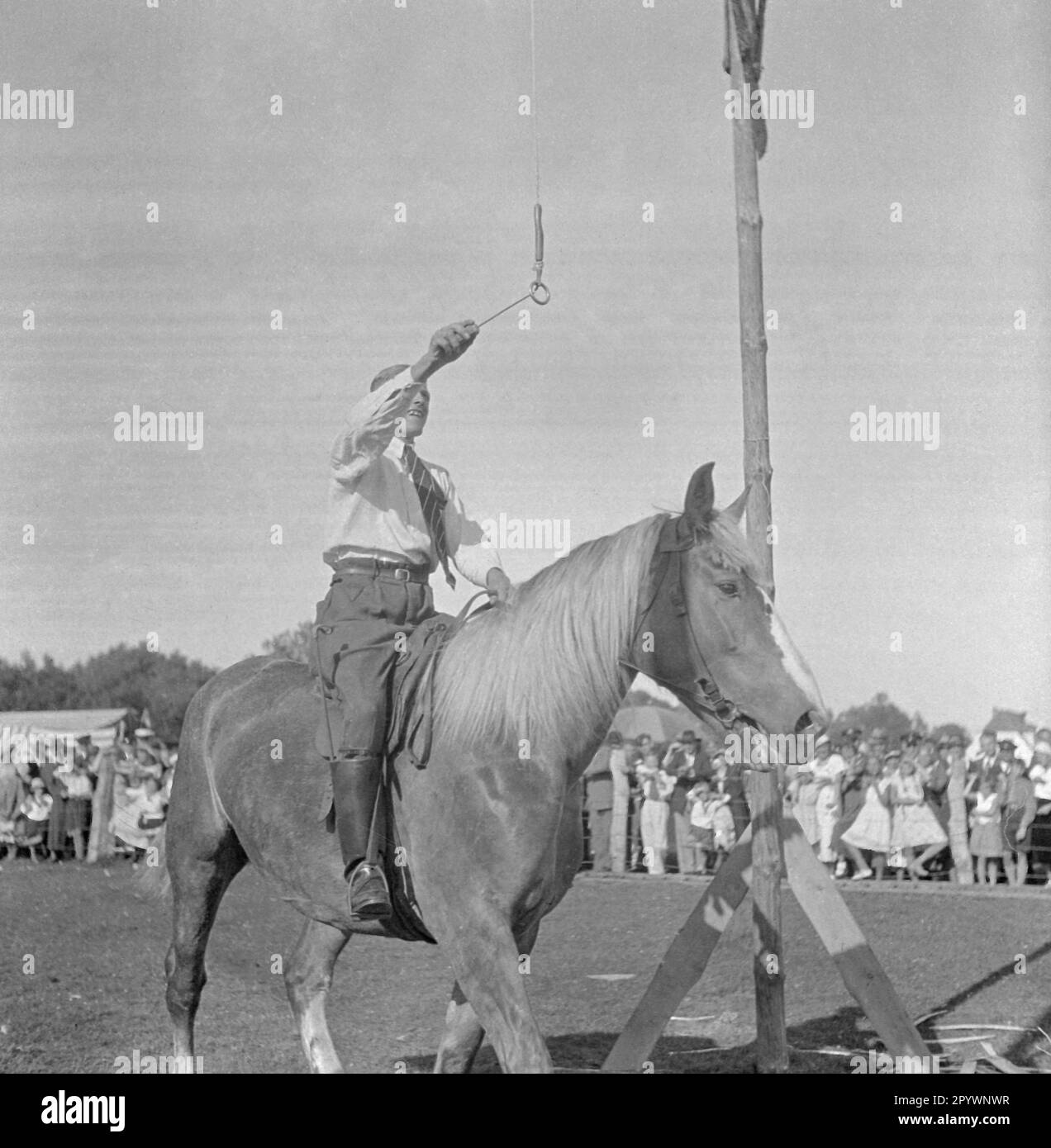 In ring riding, a lance is put through a ring hanging from a scaffold. The rider tries to hit the ring with the lance. Stock Photo