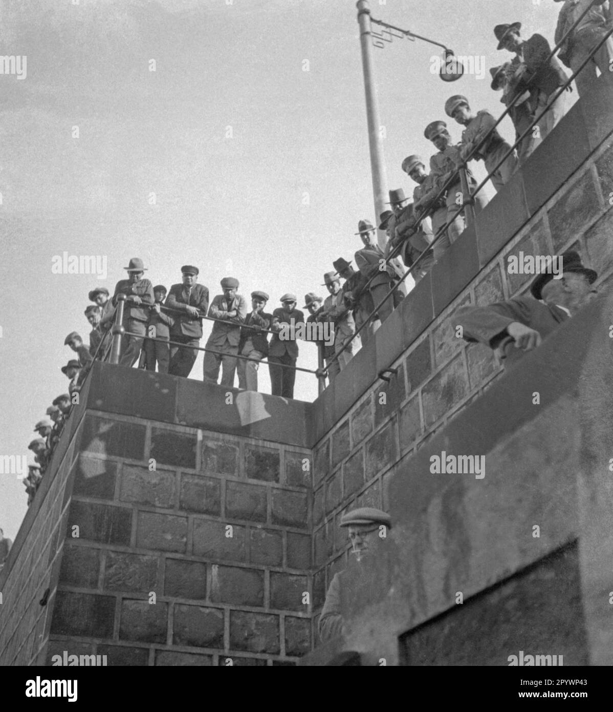 Men look at the arriving travelers Stock Photo - Alamy