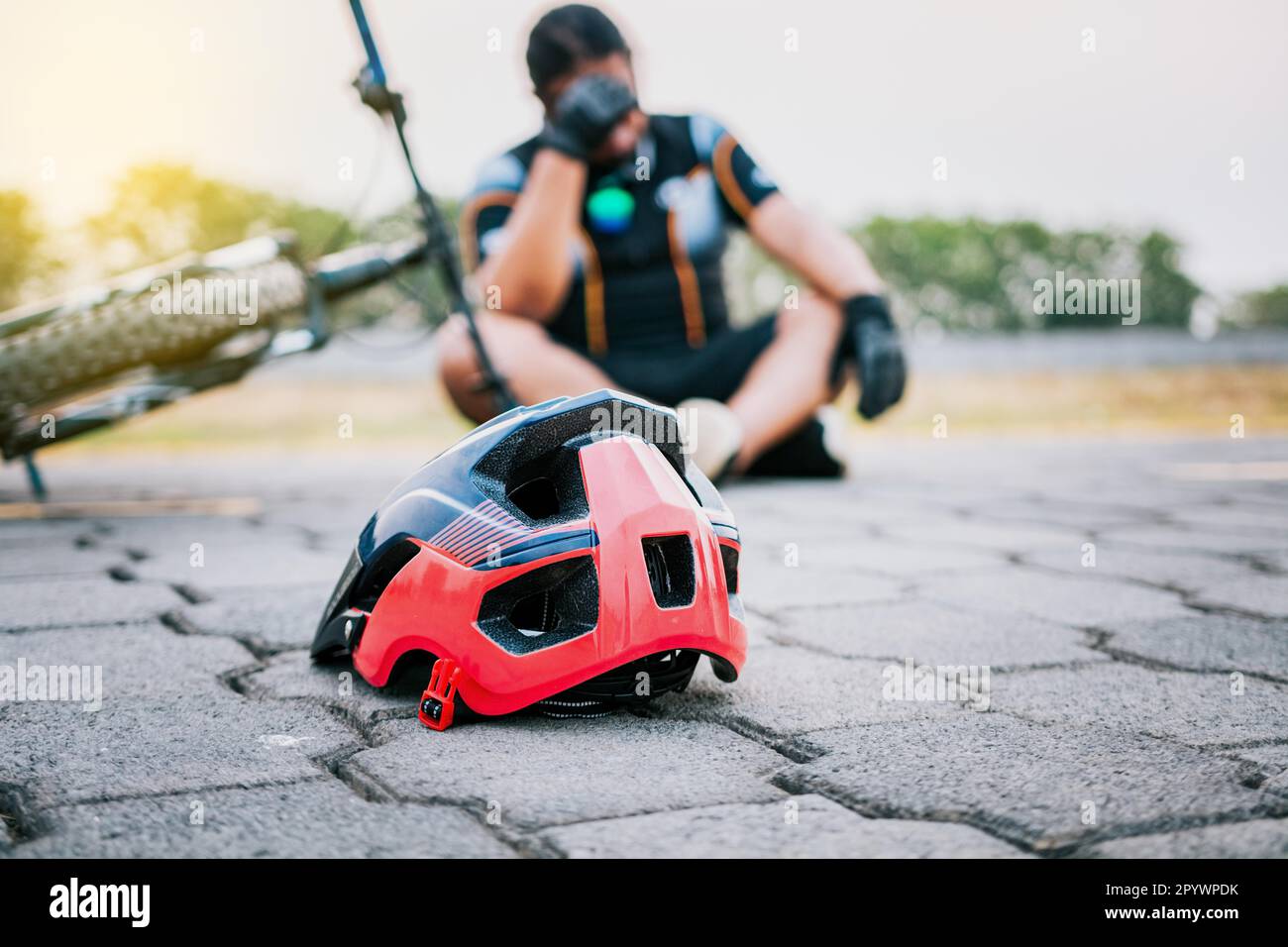 Accidented cyclist sitting on the pavement. Concept of crashed cyclist ...