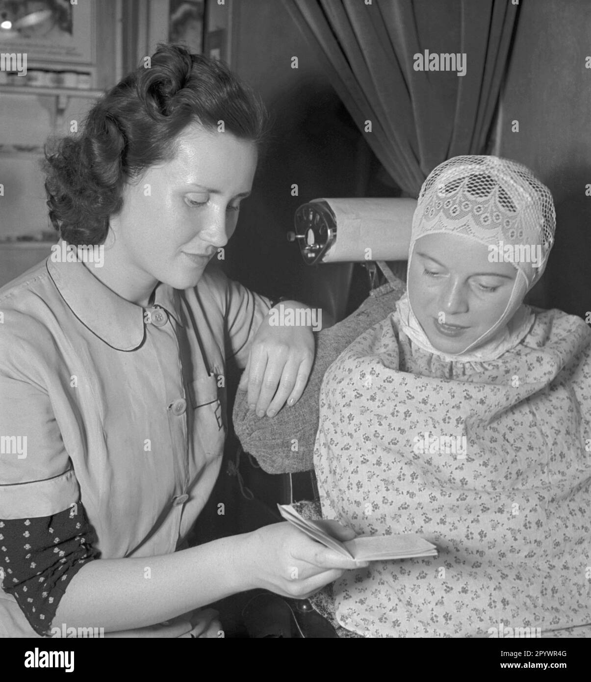 A beautician shows her patient a little book. The client receives a