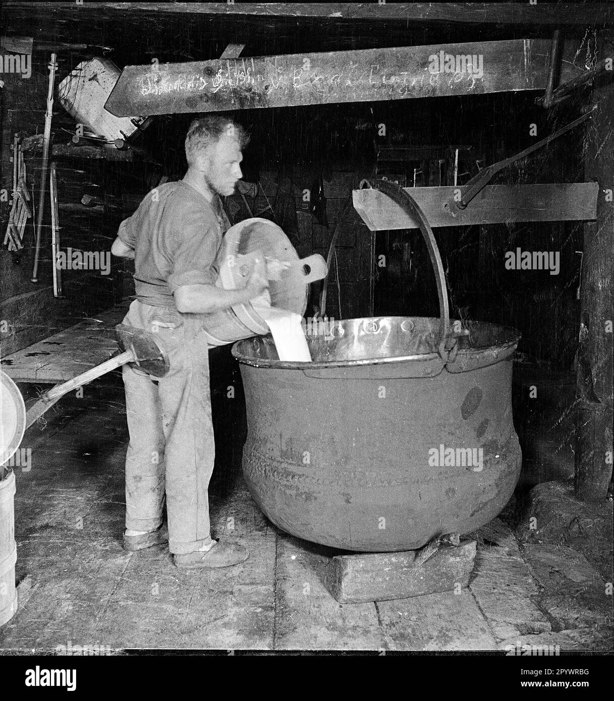 Milk is thickened in a vat. For this, rennet, a liquid from the abomasum of ruminants, will be ususally added to the milk. The milk becomes thick due to the subsequent decomposition of enzyme, but it will not be sour. Stock Photo