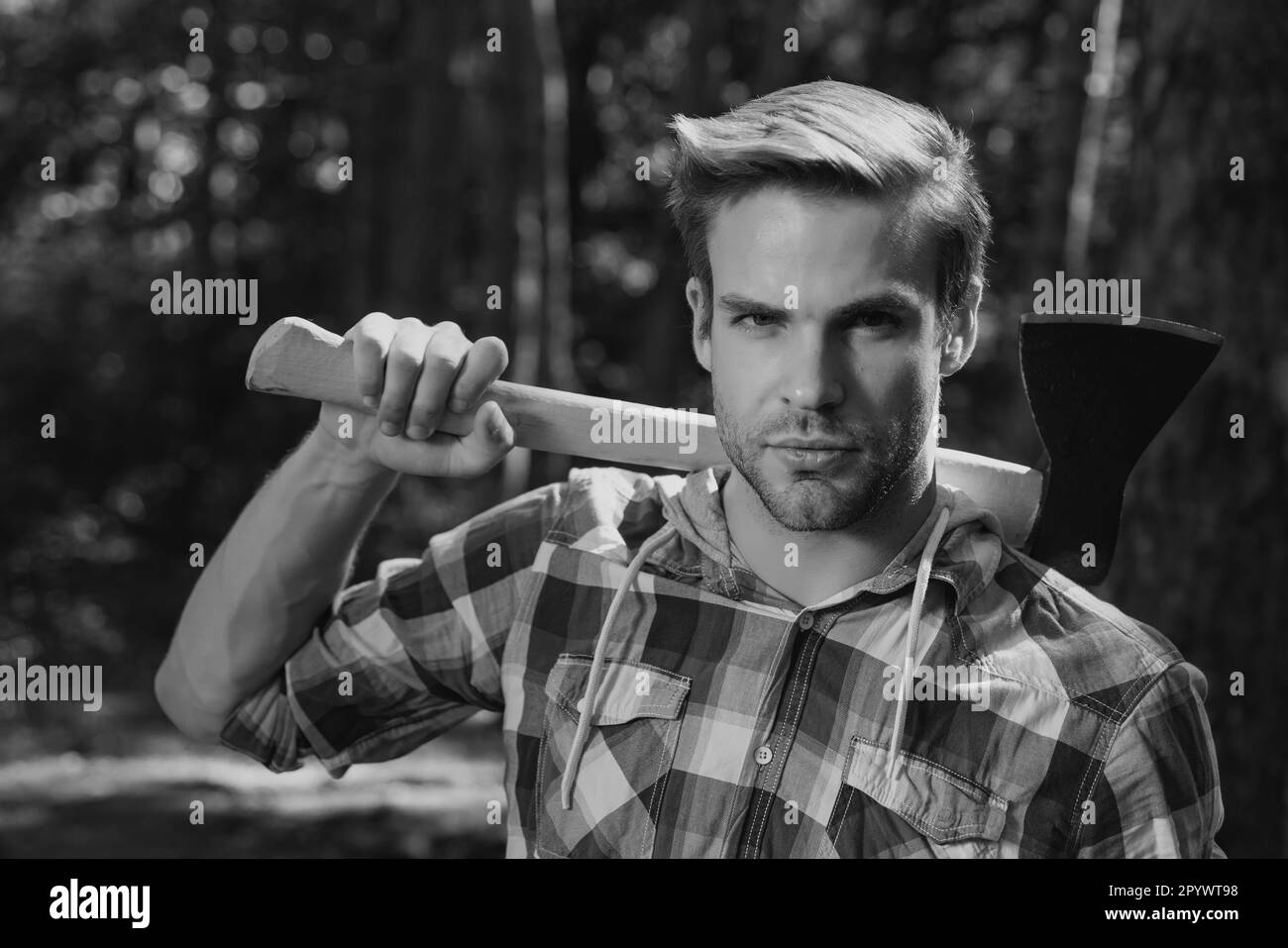 Lumberjack on serious face carries axe on shoulder Stock Photo Alamy