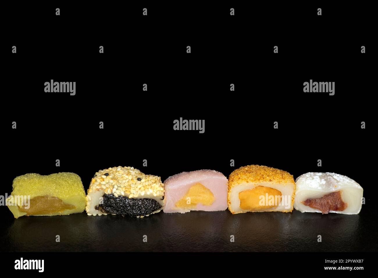 Five, halved, differently filled Japanese mochi's, rice flour cake, food photography with black