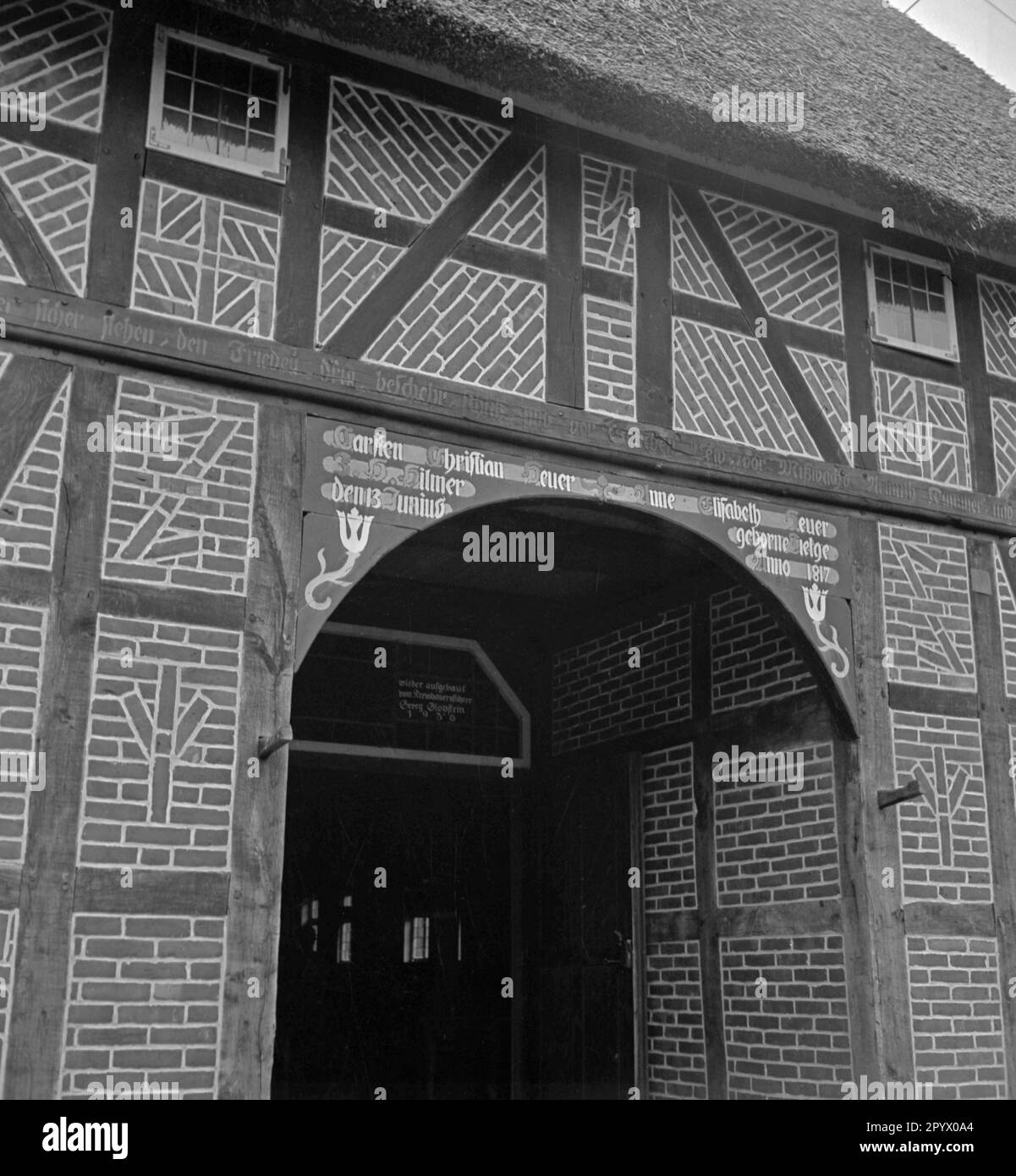 Entrance gate of a half-timber house built in 1817 near Neustrelitz. The framework is decorated with runes. Above the gate in the center, the sig rune. Left and right (from top to bottom): Swastika, Wolfsangel and Lebensrune (sig rune). Undated photo. Stock Photo