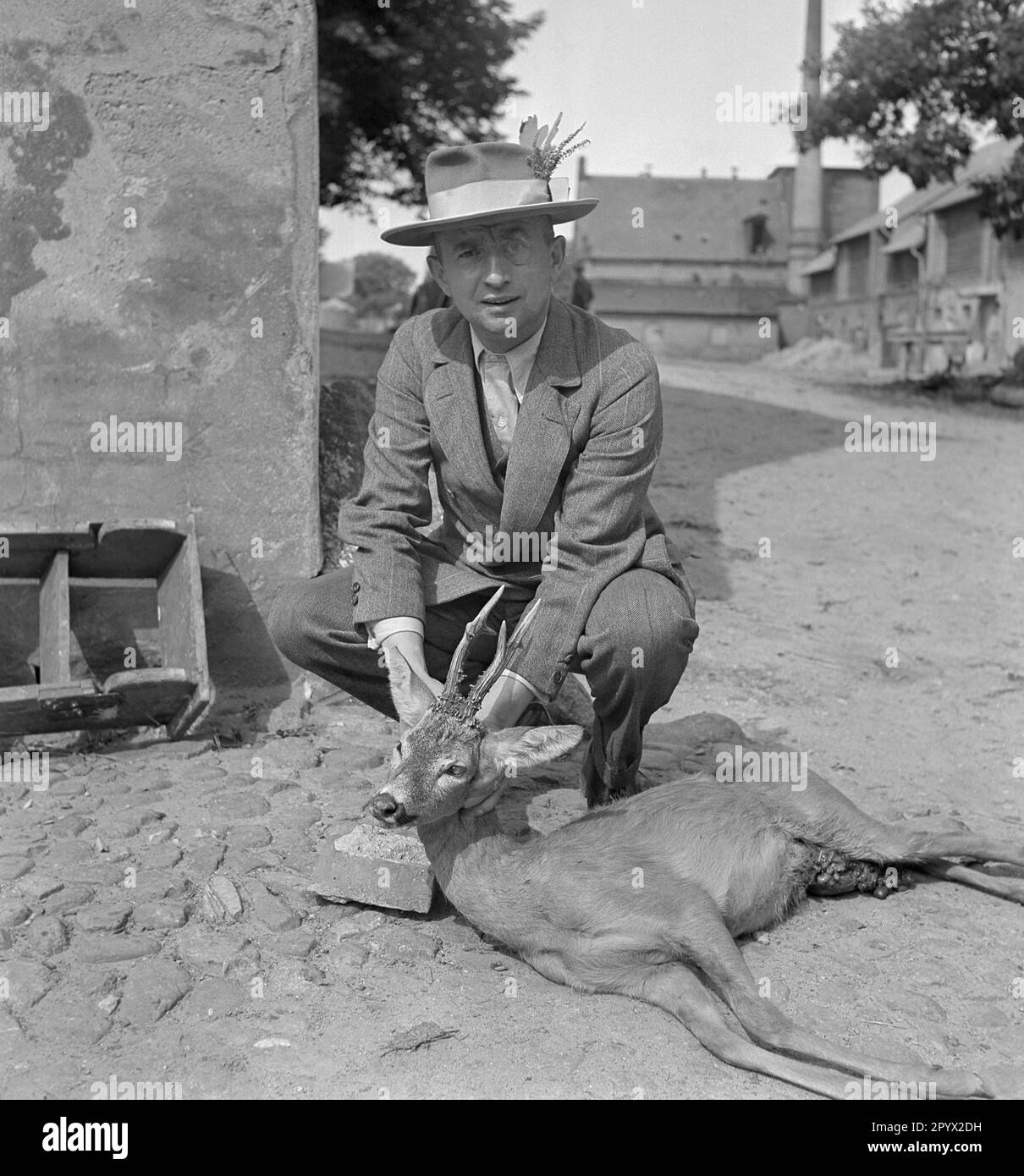 A well-dressed man poses with a killed roebuck. Undated photo, probably on a farm in the province of Pomerania in the 1930s. Stock Photo