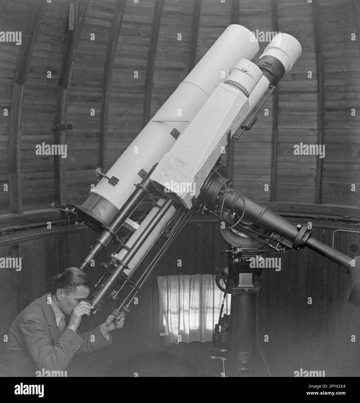 Employee looks through the 135mm lens telescope in the roof observatory