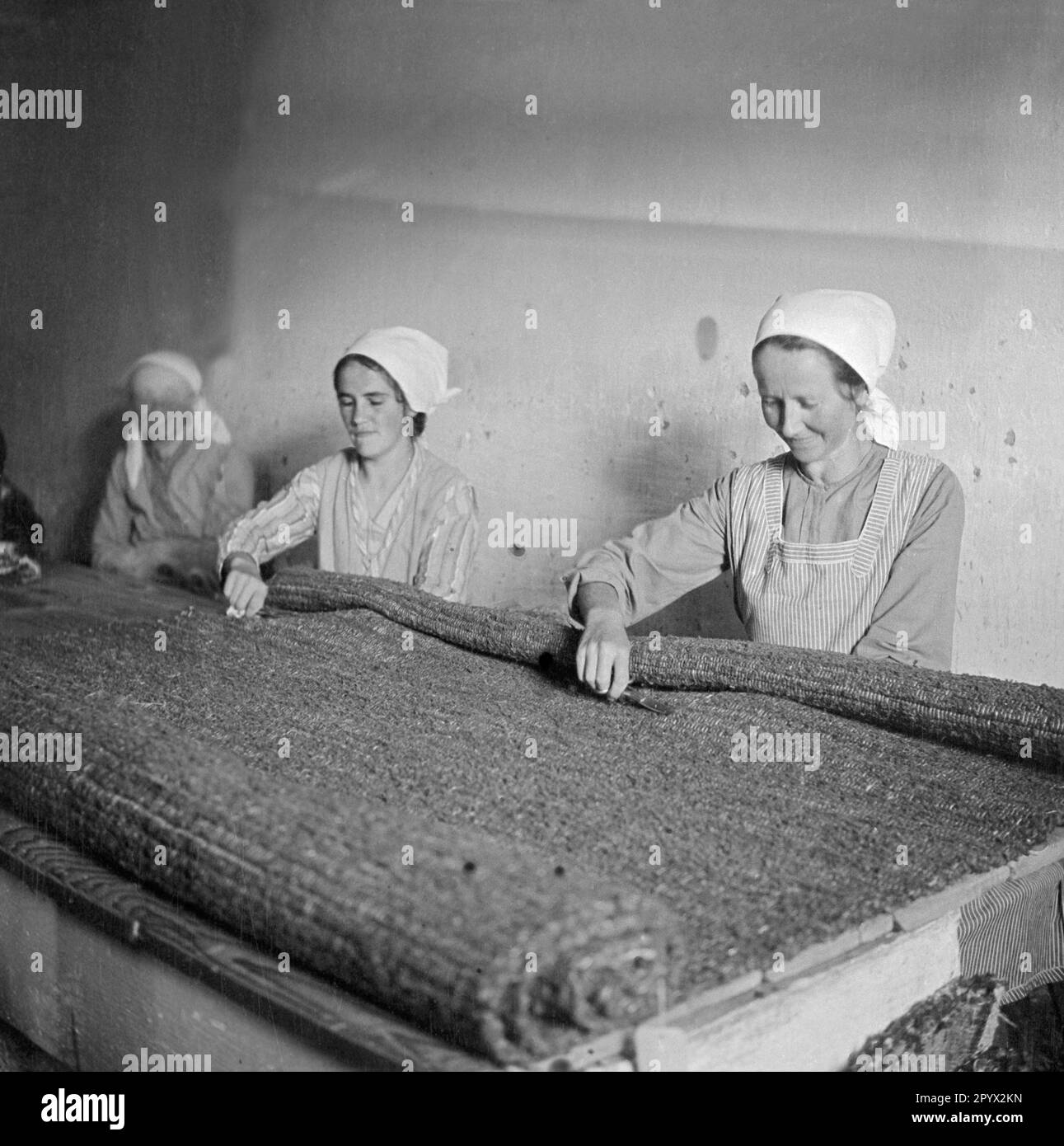 Workers cut the protruding threads of a carpet with scissors Stock ...