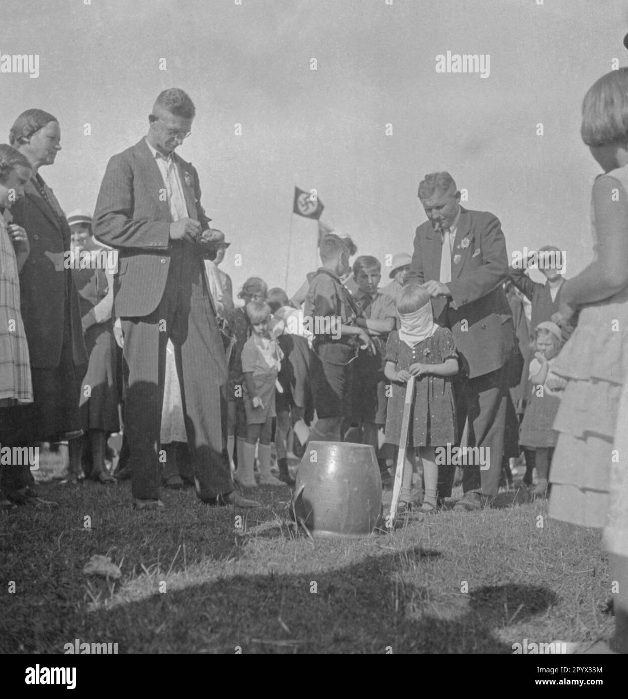 The eyes of a girl are tied for the pot hitting game as part of the