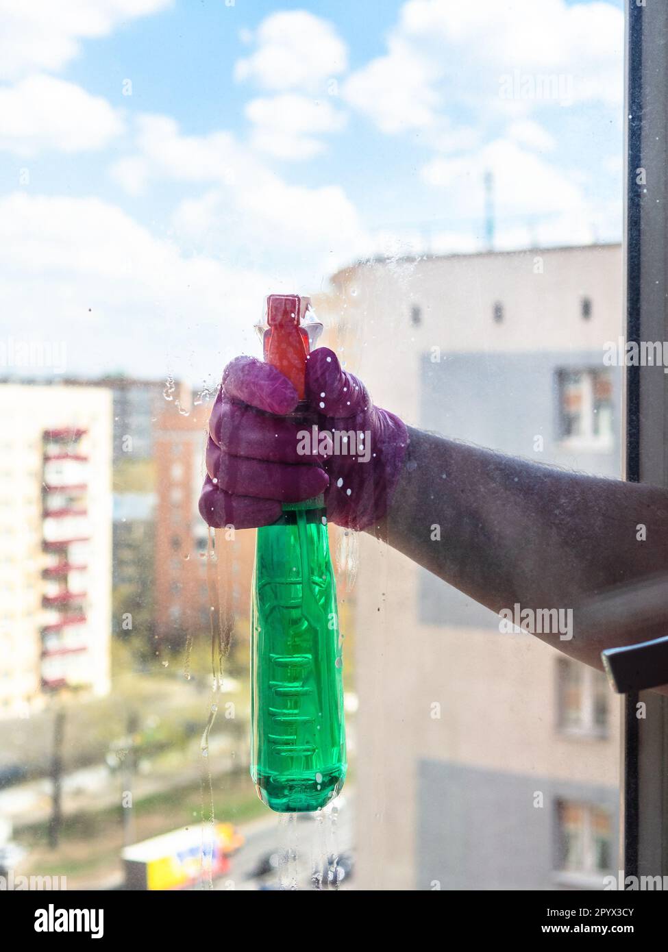 Window Liquid washing window glass in apartment in high-rise city house with washing ...