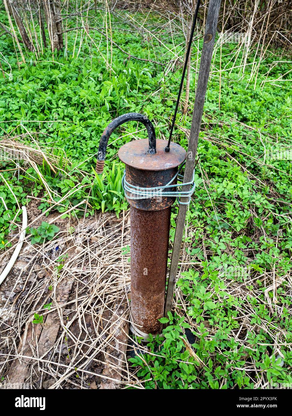 water well pipe with submersible pump in backyard in village on spring