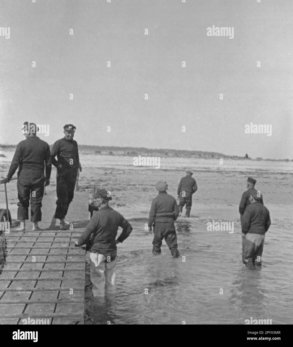 Men wade the sea on the beach of the North Sea island of Heligoland. Undated photo. Stock Photo