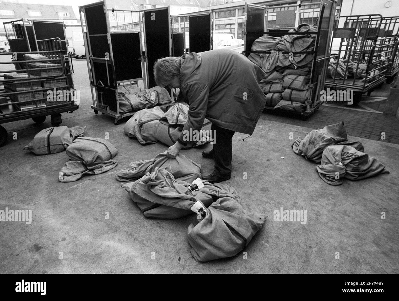 DEU , GERMANY : An employee is sorting postal bags with letters in a distribution centre of Deutsche Bundespost ( German Mail ) in Bonn , January 1992 Stock Photo