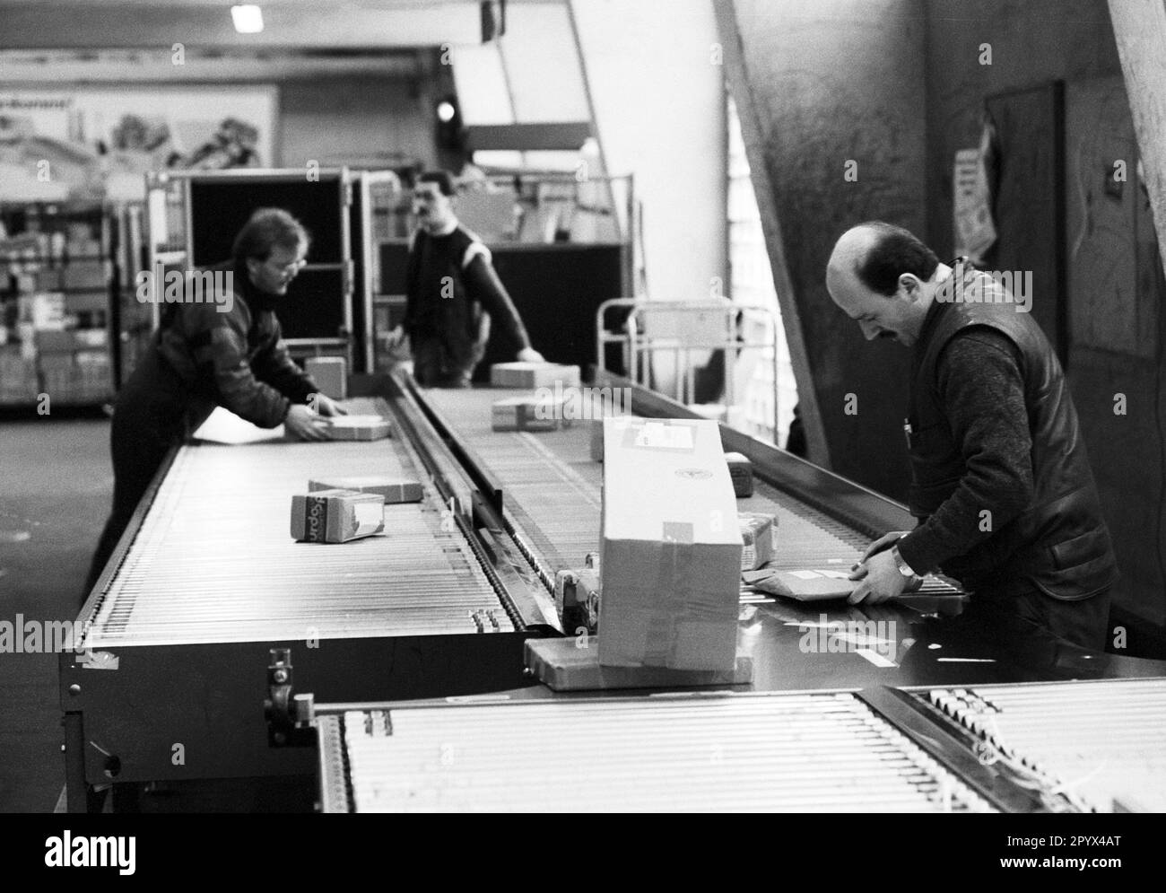 DEU , GERMANY : Employees in a distribution centre for parcels of Deutsche Bundespost ( German Mail ) in Bonn , January 1992 Stock Photo