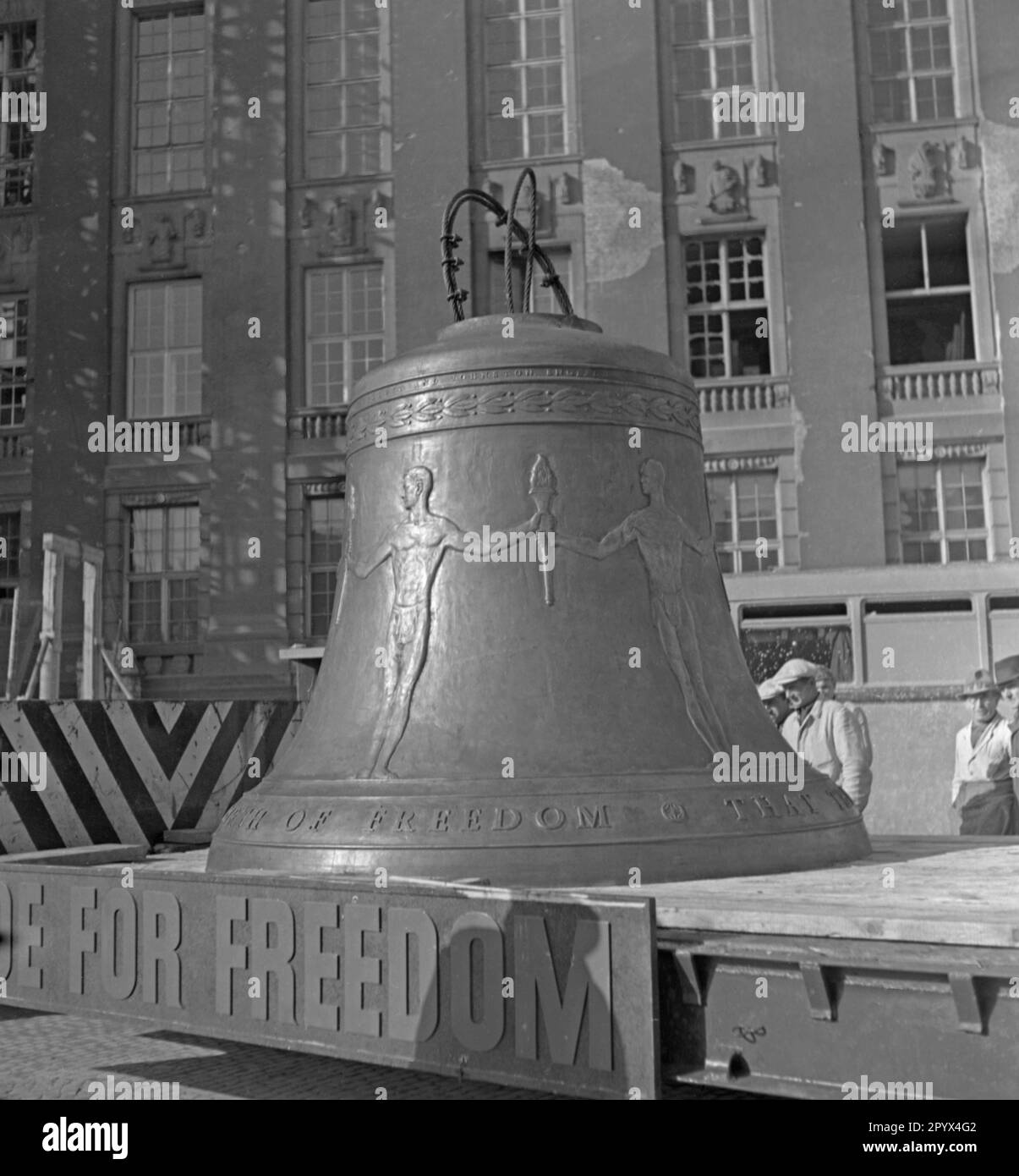 Photo of the Freedom Bell on the back of a low loader of the U.S. Army on Rathausplatz shortly before its installation in the tower of the seat of the Governing Mayor of Berlin, Ernst Reuter (1948-1953) on October 21, 1950. In the background, construction workers in front of the partially destroyed facade of the building. The bell sounded for the first time at the ceremony on the United Nations Day (UN) on 24 October. Stock Photo