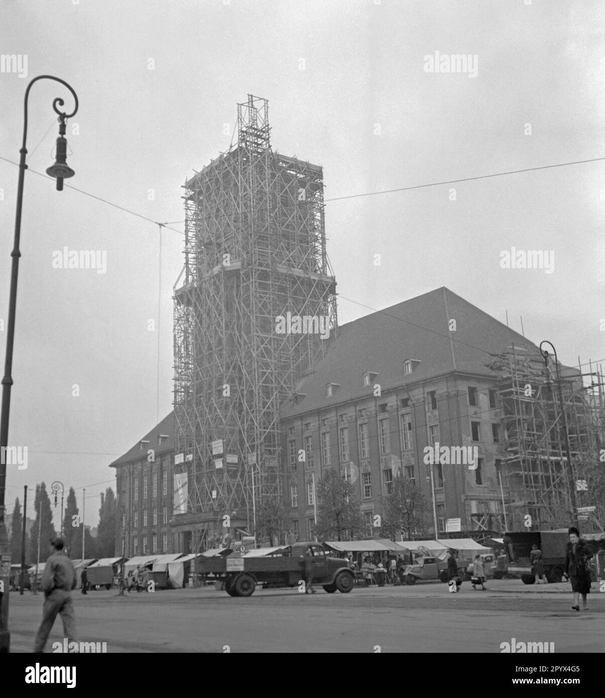 Photo of a weekly market on Rathausplatz and the decorated Rathaus Schoeneberg, the seat of the Governing Mayor of Berlin, Ernst Reuter (1948-1953) on October 21, 1950. On this date, the Freedom Bell was installed in the tower of the building. On the scaffold, a poster of the American occupation forces (inscription: Emergency Programme of Berlin with European Recovery Program). The bell sounded for the first time at the ceremony on the United Nations Day (UN) on 24 October. Stock Photo