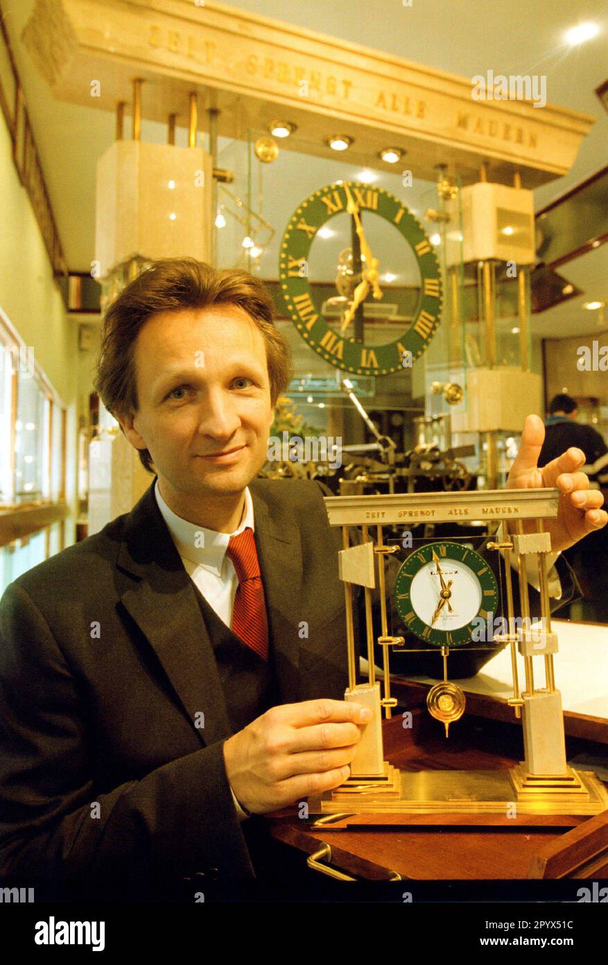 'Watchmaker Jens Lorenz with his ''Friedensuhr'', constructed this clock (the big one in the background) to symbolize that time is breaking down all walls, the inauguration in the big store in the Rheinstrasse took place in the evening of November 9th, 1989, the news of the opening of the wall suddenly burst into the celebration ..., many personalities, from the Pope to Bill Clinton, have received the small clock, DEU, Berlin-Friedenau, 06.11.1999 [automated translation]' Stock Photo