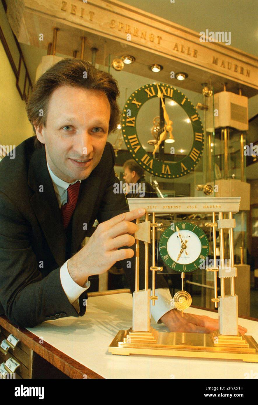 'Watchmaker Jens Lorenz with his ''Friedensuhr'', constructed this clock (the big one in the background) to symbolize that time is breaking down all walls, the inauguration in the big store in the Rheinstrasse took place in the evening of November 9th, 1989, the news of the opening of the wall suddenly burst into the celebration ..., many personalities, from the Pope to Bill Clinton, have received the small clock, DEU, Berlin-Friedenau, 06.11.1999, [automated translation]' Stock Photo