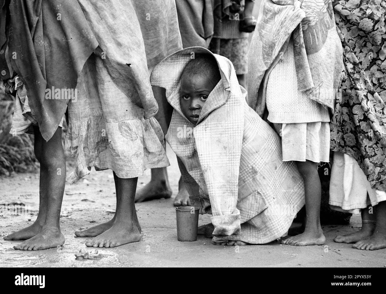 AGO , ANGOLA : A boy is waiting in line with other displaced for food rations in a camp in Malanje , they are victims of the civil war in Angola . 17.12.1993 Stock Photo