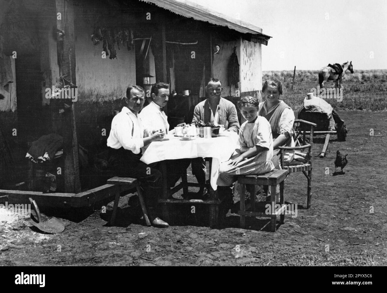 German family having dinner in front of their house in Chaco province, northern Argentina. [automated translation] Stock Photo