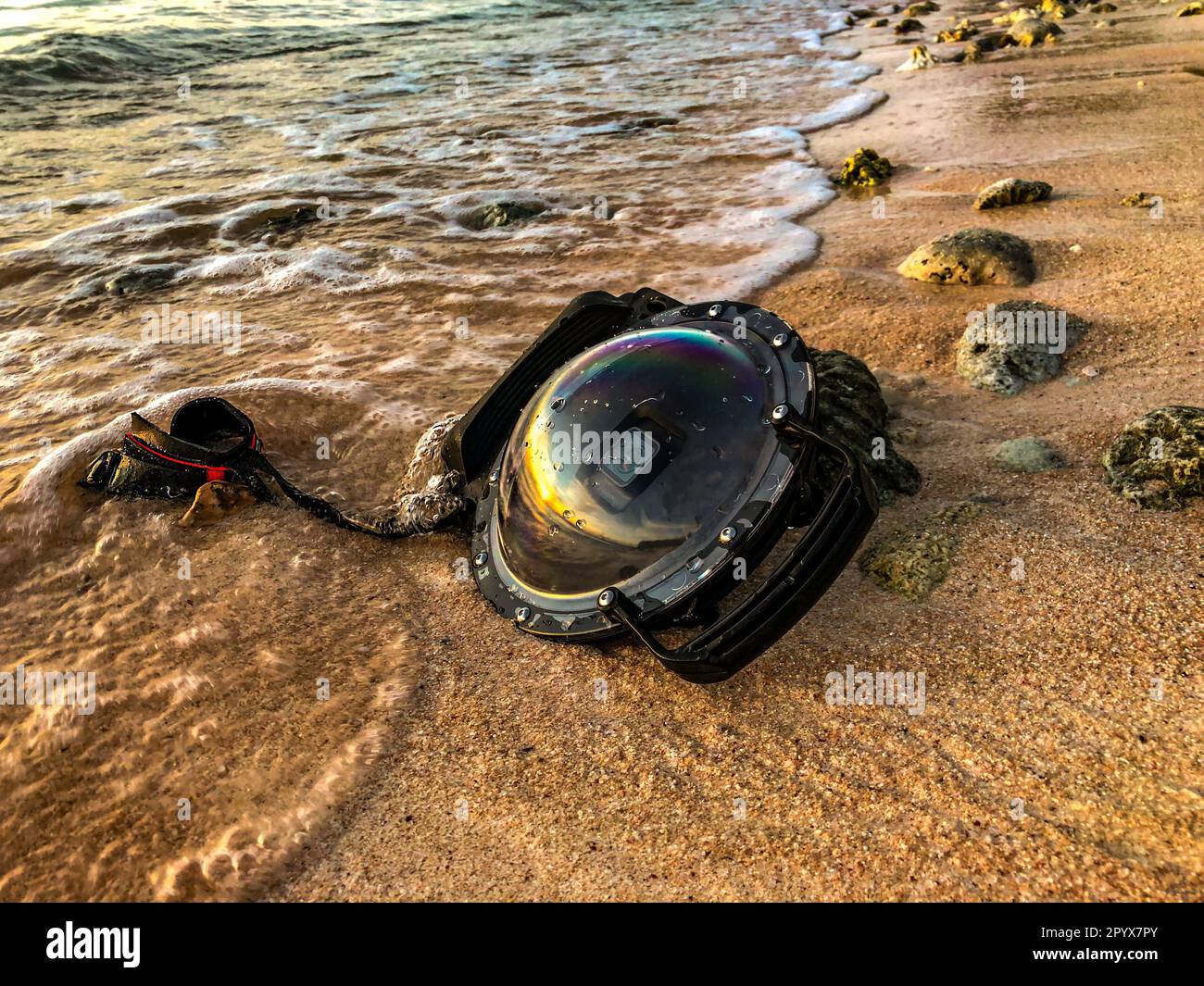 A Dome Underwater camera on beach with waves washing on it, Guam Stock