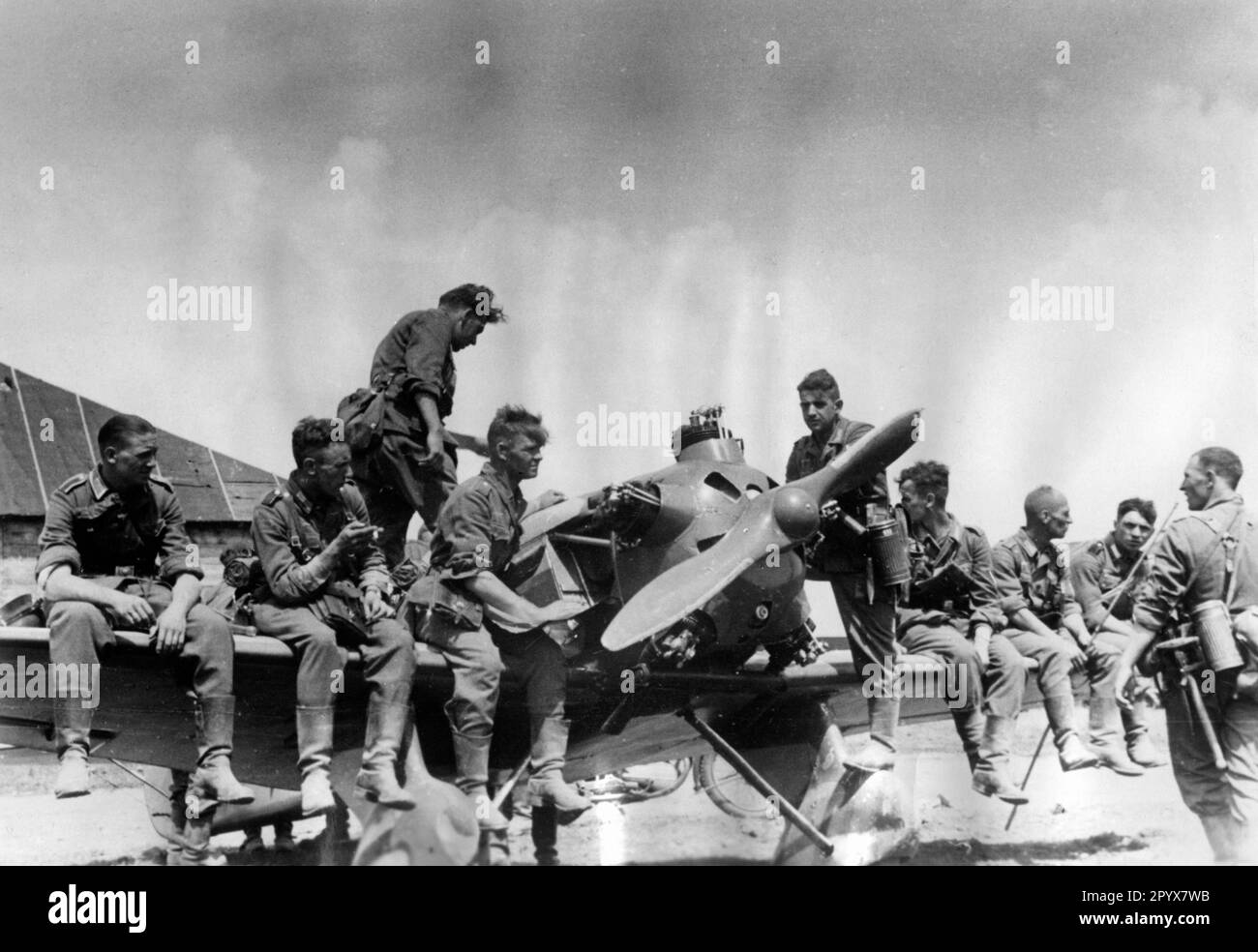 German infantrymen resting on a destroyed Russian plane near Dubno (Ukraine, southern section of the Eastern Front) during the advance in the summer of 1941. Photo: Müller [automated translation] Stock Photo