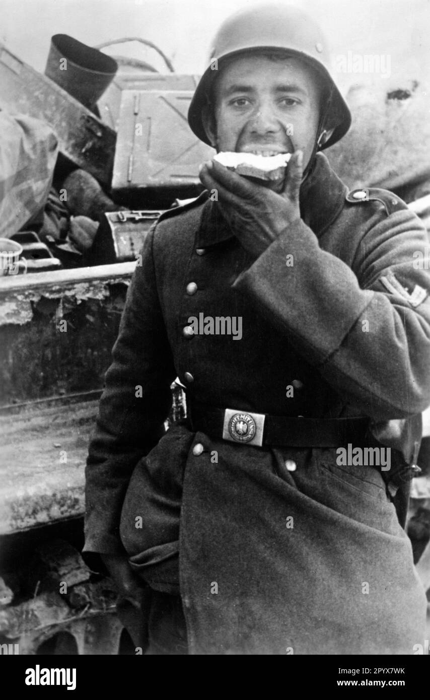 On the Eastern Front: Soldier eating a loaf of bread during the fighting near Ramushevo in the northern section of the Eastern Front during the opening of the Demyansk cauldron (Operation Bridge Strike). Photo: Kuhn. [automated translation] Stock Photo