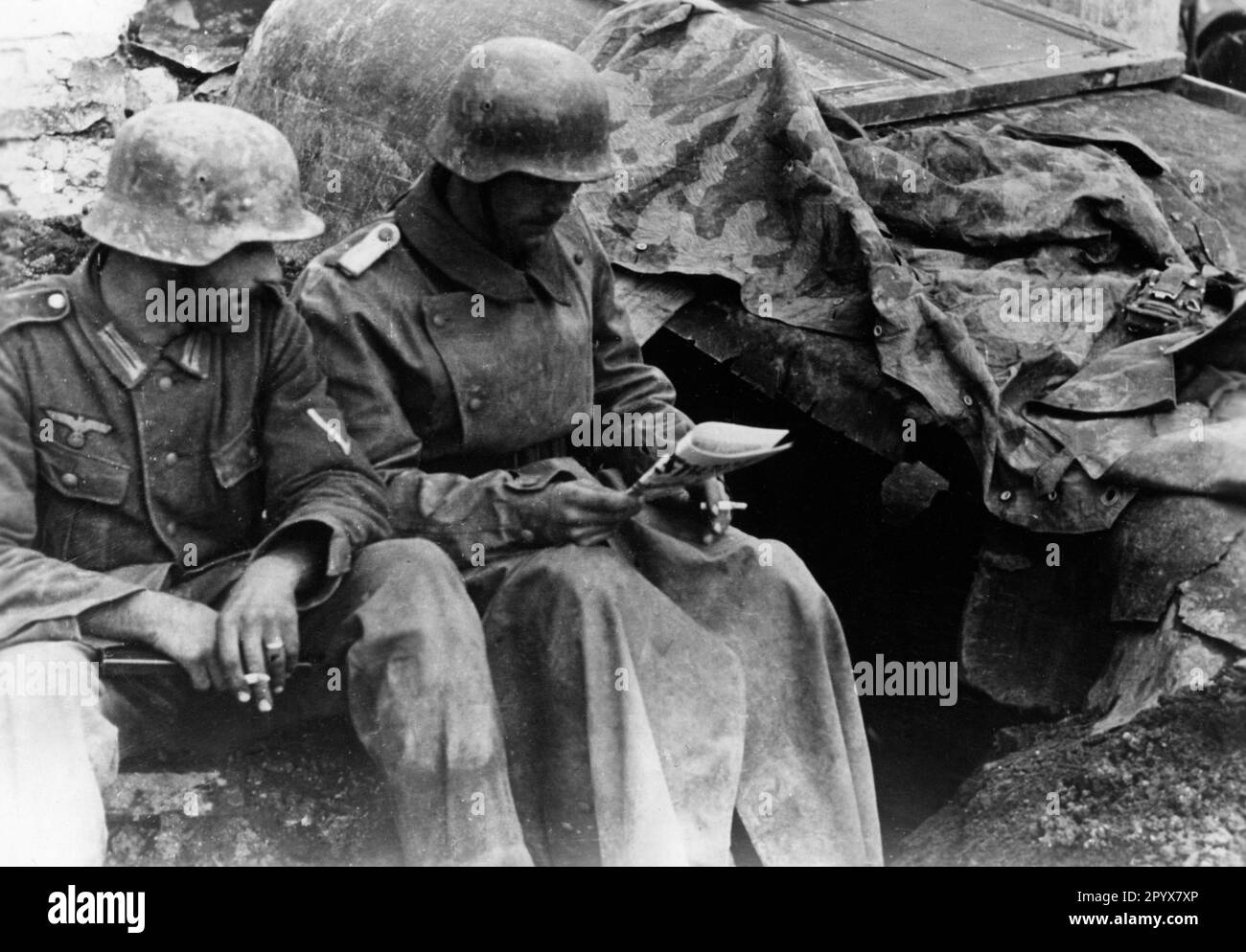 Soldiers reading newspaper near Koporje in northern section of Eastern Front. Photo: Schürer. [automated translation] Stock Photo