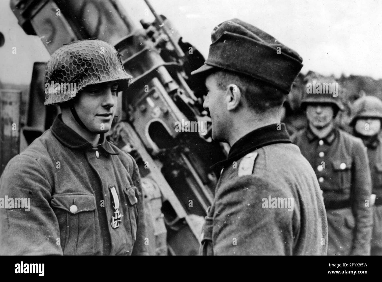 A flak gunner of the Reich Labor Service receives the Iron Cross as a decoration from his commander. [automated translation] Stock Photo