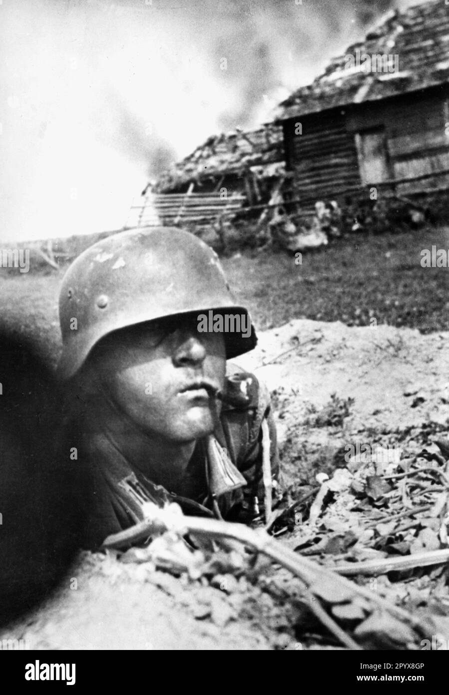 A soldier smokes a pipe during the fighting on the Eastern Front. Photo